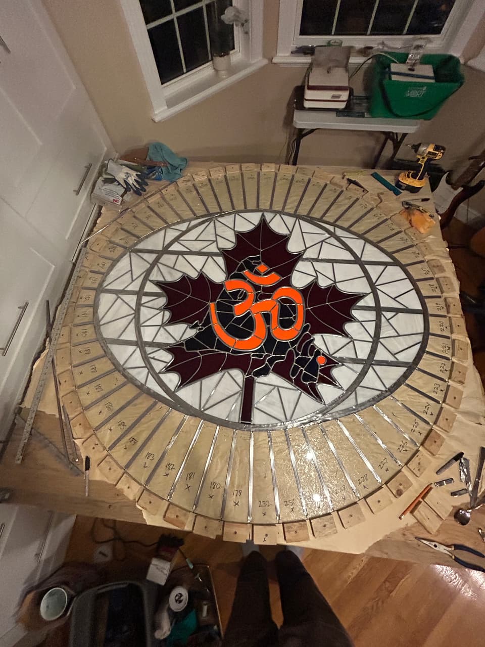 Overhead view of the circular temple panel with the Om in the maple leaf at the centre and a white and clear border ring